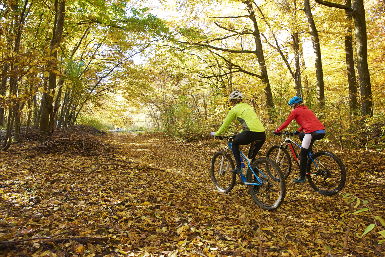 two woman biking in the woods-Destination Properties